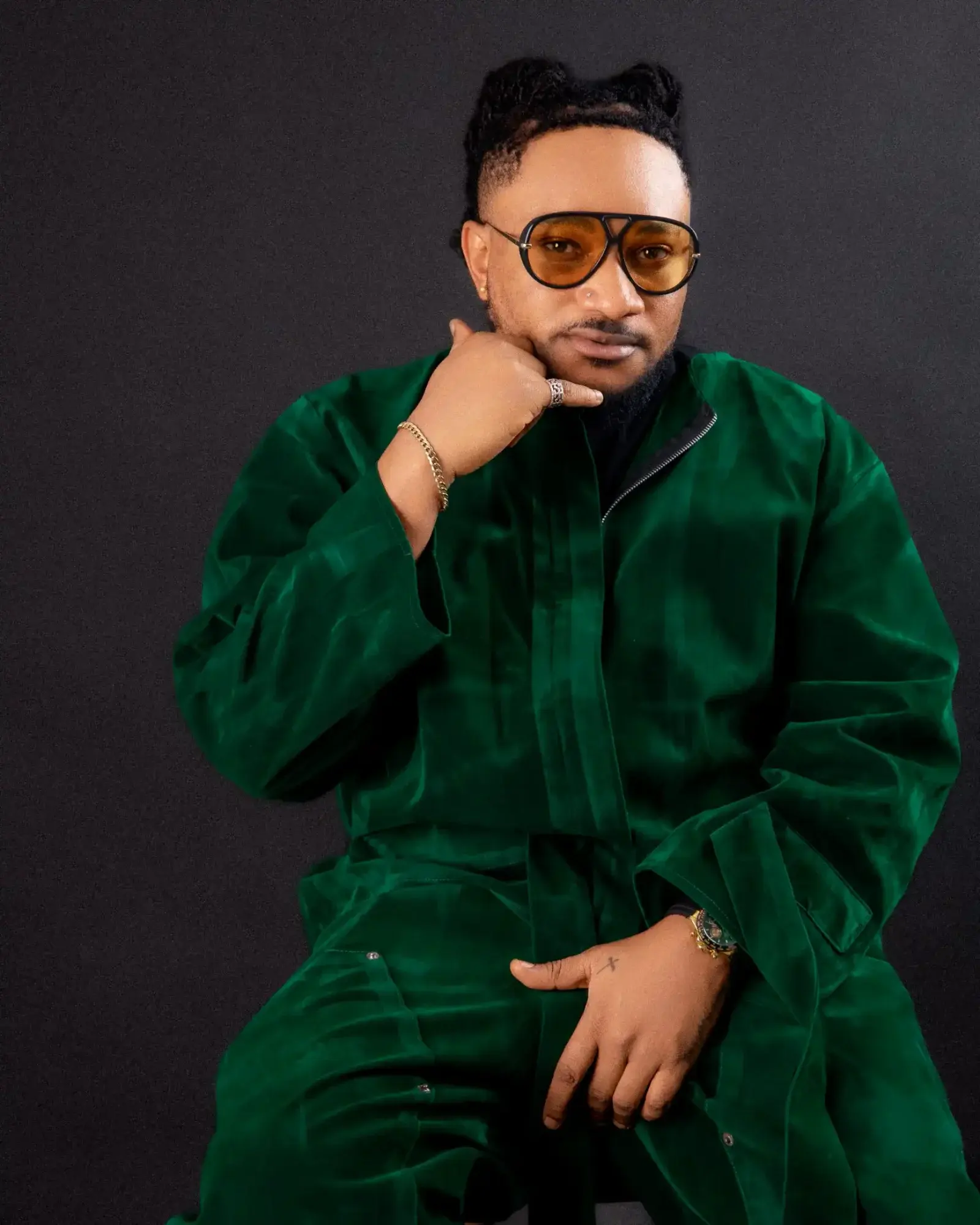 Masterkraft in a green velvet suit and amber sunglasses