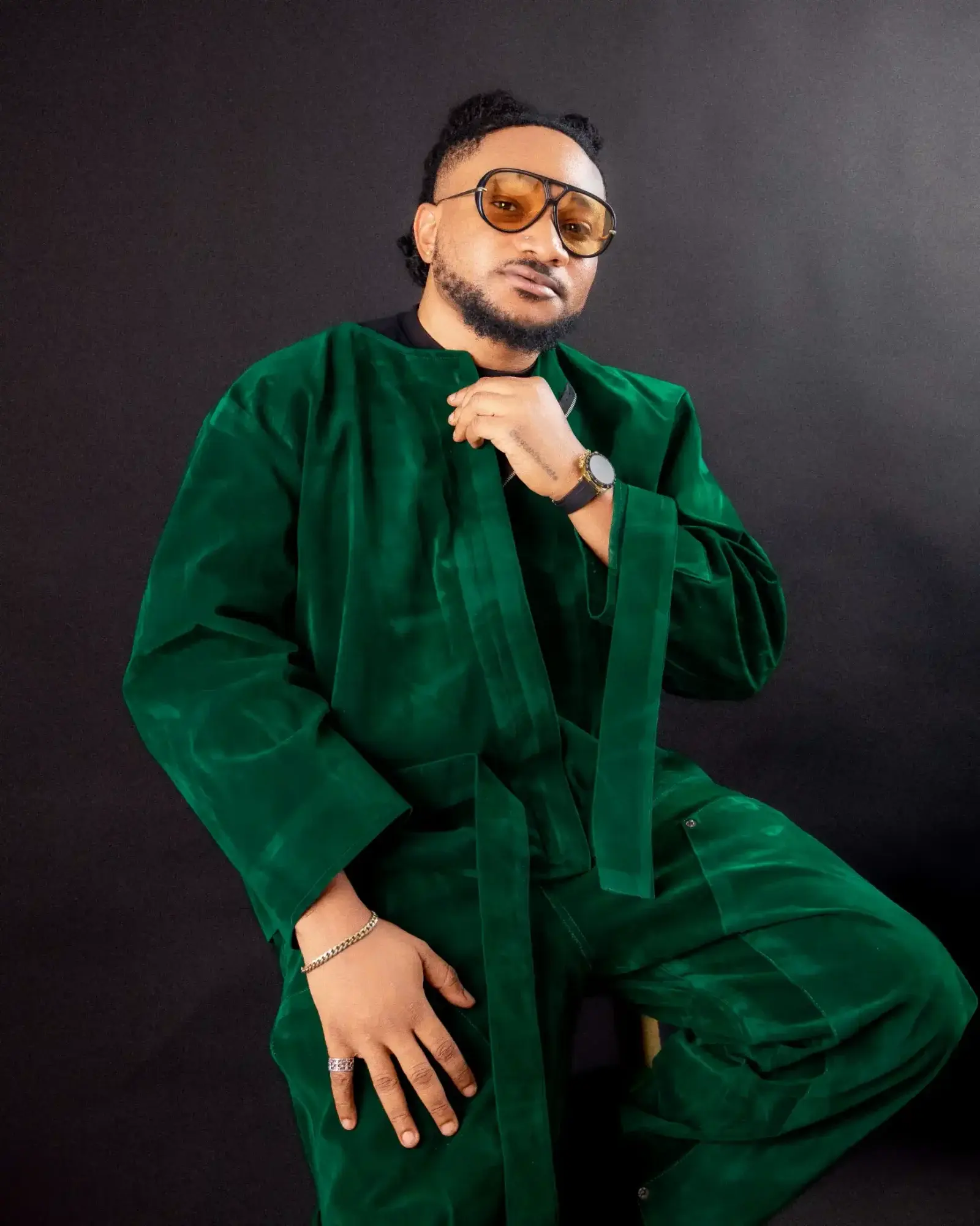 Masterkraft seated in a green velvet suit